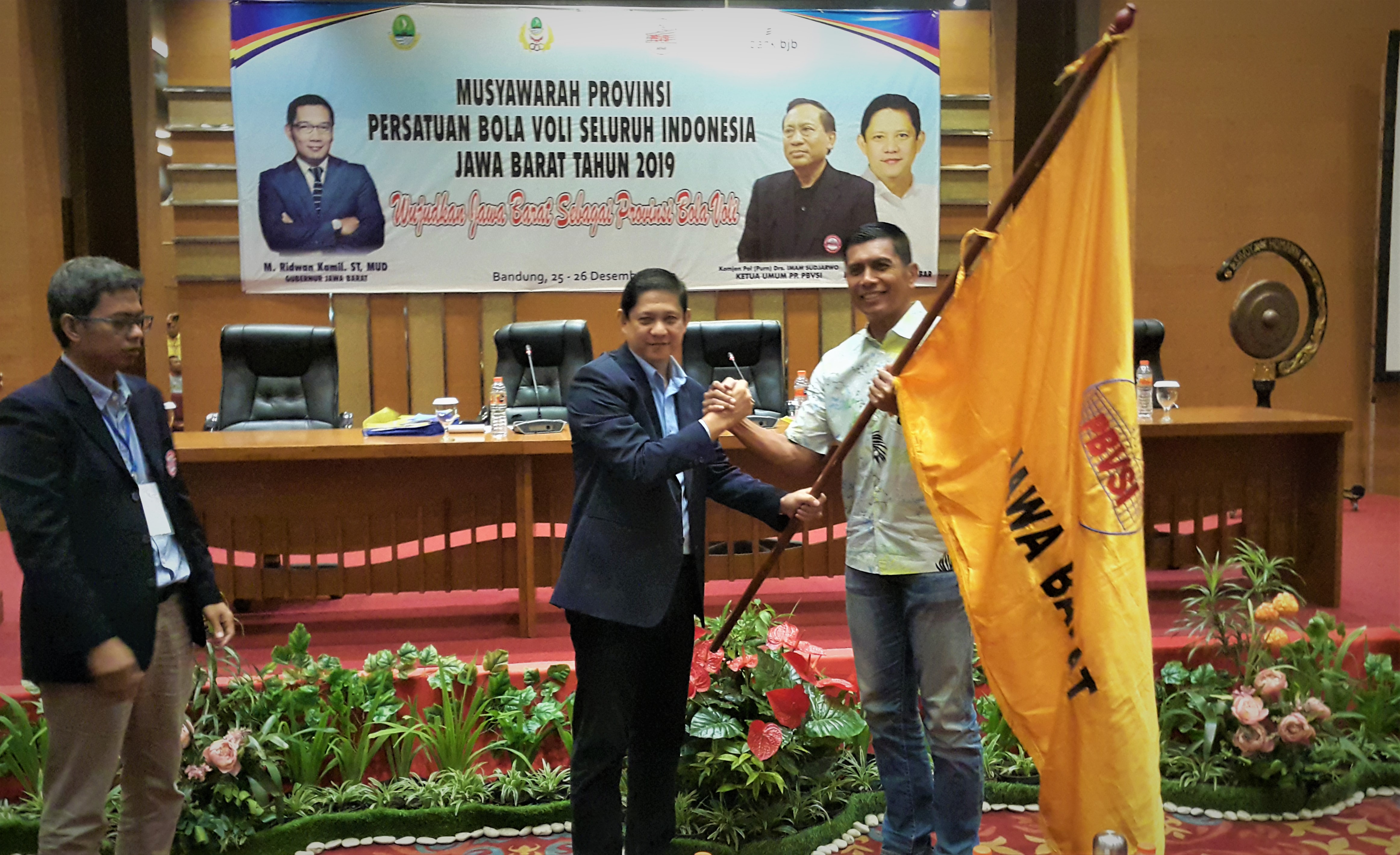 H. MQ Iswara menyerahkan bendera pataka PBVSI Jabar kepada Rudy Sufahriadi sebagai Ketua Umum PBVSI Jabar 2019-2023. (FOKUSJabar/Ageng)