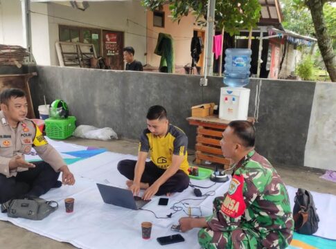 Caption: Bhabinkamtibmas Polsek Banjar Bripka Riyan Bramandita dan Babinsa Serka Fhaturahman sedang berbincang dengan tokoh masyarakat