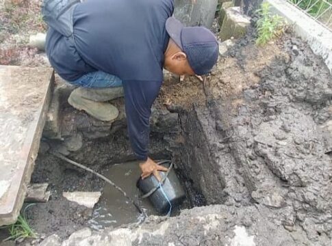 Caption: Salah seorang pekerja dari DPUTR Kota Banjar sedang membuang tanah yang menumpuk di bak kontrol jalan Perintis Kemerdekaan