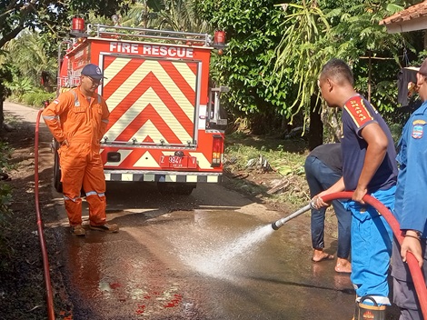 Poto: Petugas Damkar saat membersihkan lumpur di jalan wilayah Desa Ciganjeng.