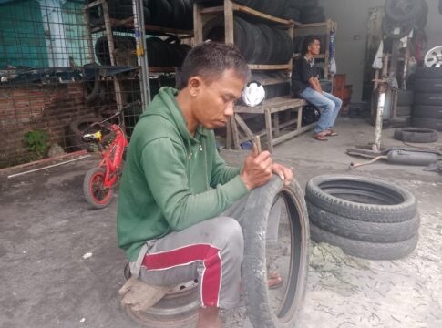 Poto: Yanto, warga Pangandaran mengukir ban bekas untuk di jual kembali.