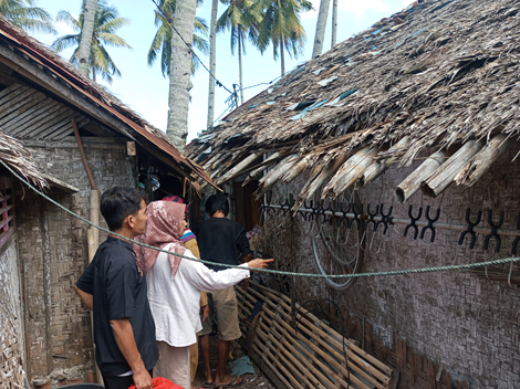 Poto: Anggota DPRD Pangandaran, Sri Rahayu saat memperbaiki dinding rumah yang terbuat dari anyaman bambu yang bolong