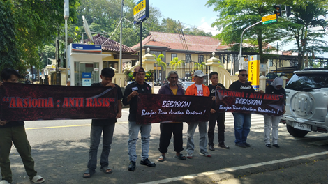 Caption: Elemen masyarakat membentangkan spanduk di depan Mako Polres Banjar