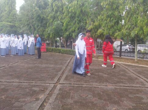 Caption: Petugas PMI mengandeng peserta upacara yang mengalami pusing saat upacara HSP Caption: Petugas PMI mengandeng peserta upacara yang mengalami pusing saat upacara HSP