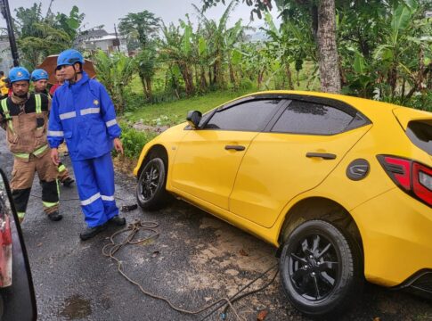Keterangan Foto: Petugas Dinas Pemadam Kebakaran Kabupaten Garut mengevakuasi satu unit mobil yang terperosok di area Perumahan Griya Mutiara Blok C No. 16, Desa Rancabango, Kecamatan Tarogong Kaler, pada Kamis (04/12/2025) sore. Insiden ini terjadi setelah jalan tempat mobil diparkir ambruk akibat curah hujan tinggi.