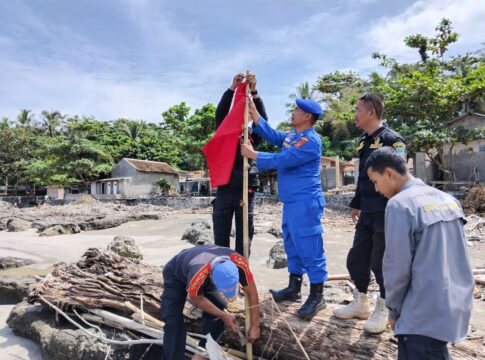 Keterangan Foto: Anggota Satuan Polisi Perairan dan Udara (Sat Polairud) Polres Garut memasang pos pantau, bendera merah, serta spanduk larangan berenang di kawasan wisata pantai selatan Kabupaten Garut, Rabu (24/12/2025). Langkah ini dilakukan dengan guna mencegah terjadinya kecelakaan laut (laka laut) bagi wisatawan.