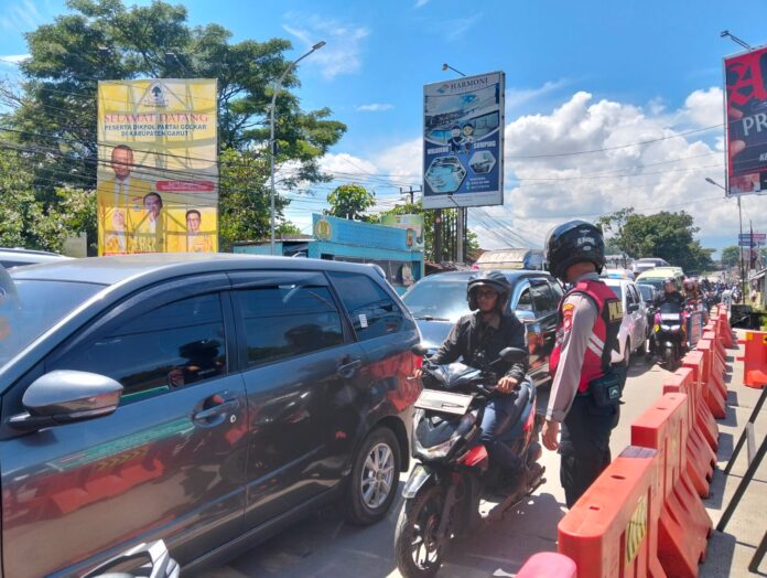 Keterangan Foto: Personel Polres Garut mengatur kendaraan menuju kawasan objek wisata Cipanas, Kabupaten Garut, Minggu (28/12/2025). Lonjakan kunjungan wisatawan ke kawasan ini, mengharuskan Polres Garut memberlakuka lalu lintas sistem satu arah (one way).