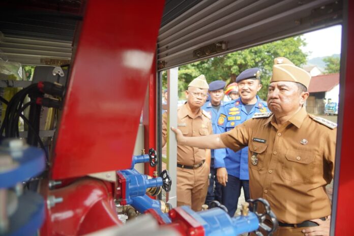 Keterangan Foto: Bupati Garut, Abdusy Syakur Amin, menyerahkan secara simbolis satu unit Kendaraan Unit Pancar Pemadam Kebakaran (Damkar) terbaru dalam apel gabungan di Lapangan Sekretariat Daerah, Jalan Pembangunan, Kecamatan Tarogong Kidul, Senin (29/12/2025).