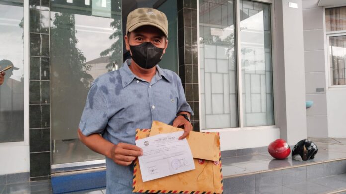 Caption: Andri Setiawan warga Desa Rejasari menunjukan bukti laporan pengaduan ke Inspektorat Banjar