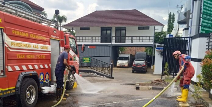 Ketpot: Personel Damkar UPTD Ciamis saat membersihkan material sisa proyek pembangunan gedung Kejari Ciamis