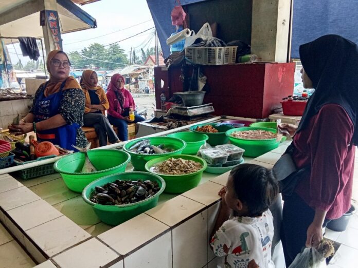Ketpot: Yati seorang penjual ikan laut segar di pasar ikan terpadu Pasar Manis Ciamis saat melayani konsumen