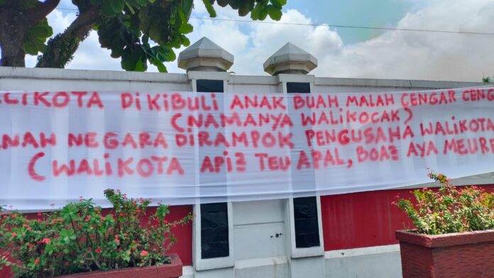 Ket foto : Bentangan spanduk berukuran besar terpampang di pagar Kantor Balekota Tasikmalaya yang bernarasikan kritikan pedas terhadap Wali Kota (fokusjabar/Seda) Tasikmalaya, FOKUSJabar.id