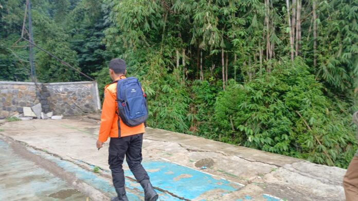 Keterangan Foto: Tim Badan Penanggulangan Bencana Daerah (BPBD) Kabupaten Garut melakukan assesment kondisi infrastruktur Tembok Penahan Tanah (TPT) di lingkungan SMP As-Saefulloh, Desa Situsari, Kecamatan Cisurupan, Selasa (10/2/2026). Berdasarkan hasil asesmen terbaru, struktur penahan lapangan sekolah tersebut mengalami retakan serius dan terancam ambruk akibat pergerakan tanah. Garut, FOKUSJabar.id