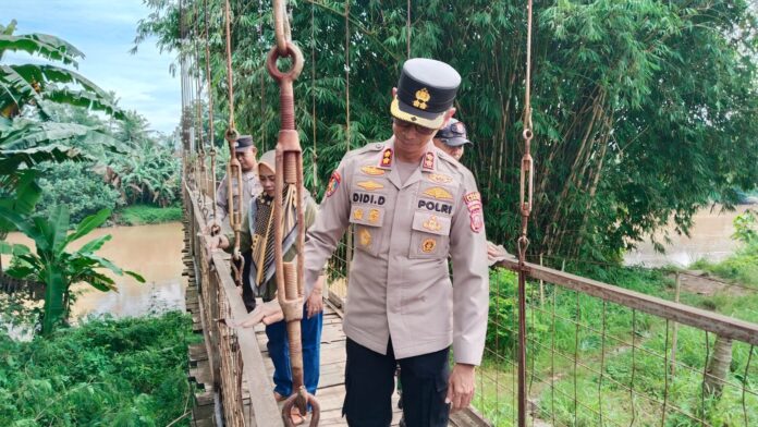 Caption: Kapolres Banjar AKBP Didi Dewantoro sedang meninjau jembatan gantung penghubung Jabar - Jateng. (Agus Purwadi/fokusjabar.id) Banjar, FOKUSJabar.id