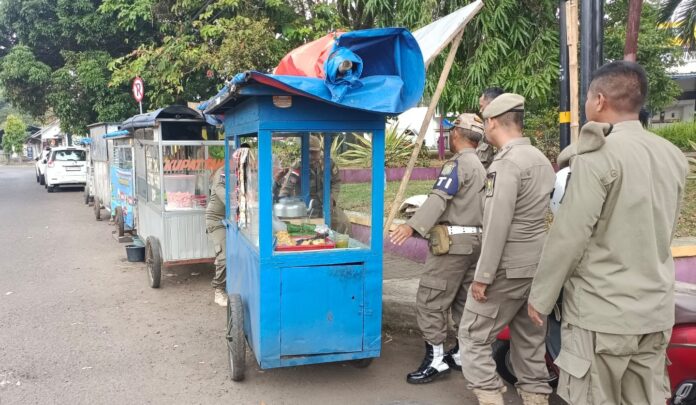 Ketpot: Personel Satpol PP Kabupaten Ciamis saat membantu PKL Permata Bunda untuk berpindah tempat berjualan ke lokasi yang tidak dilarang CIAMIS, FOKUSJabar.id
