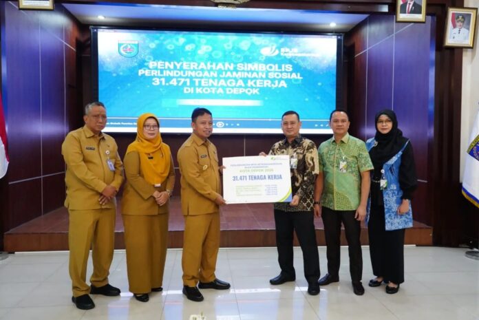 Launching program PEKA BPJS Ketenagakerjaan di Kota Depok dirangkai dengan pemberian simbolis pemberian santunan kepada para penerima manfaat oleh Direktur Pelayanan BPJS Ketenagakerjaan, Trisna Sonjaya (ketiga kiri). Depok, FOKUSJabar.id